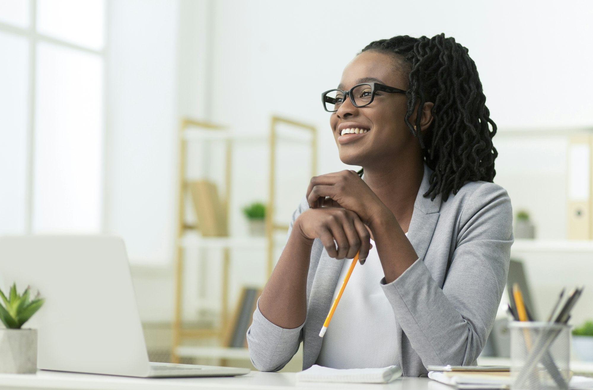 Smiling Black Business Lady Sitting At Laptop At Workplace